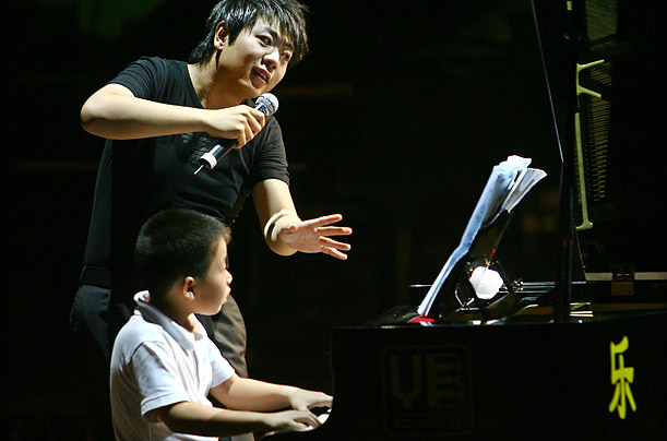 lang lang teaches a young boy piano techniques before his own solo concert in Nanjing, China