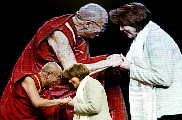 The Dalai Lama presents a scarf to Pelosi during a public talk in Washington.  Pelosi has been a critic of the way the People's Republic of China has handled unrest in Tibet.