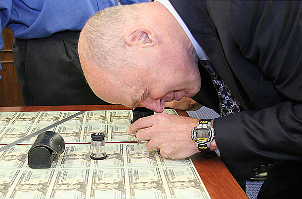 Paulson examines his signature on newly printed twenty-dollar bills in October 2006 at the Bureau of Engraving and Printing in Washington, D.C..