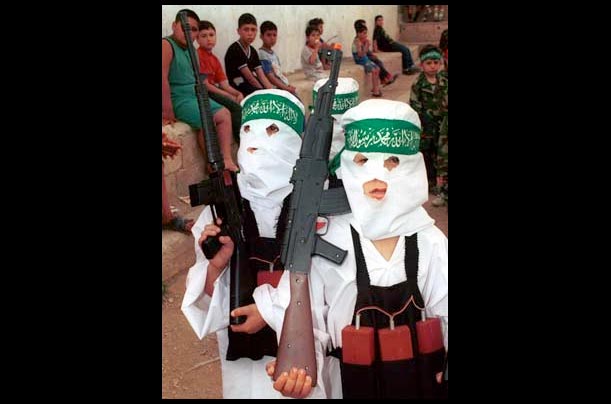 Two children with fake explosives strapped to their waists carry plastic rifles during a demonstration at the Ein el-Hilweh Palestinian refugee camp outside Sidon