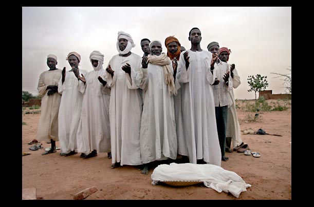 Relatives mourn a year-old child who died of malnutrition in a refugee camp in Darfour, Sudan