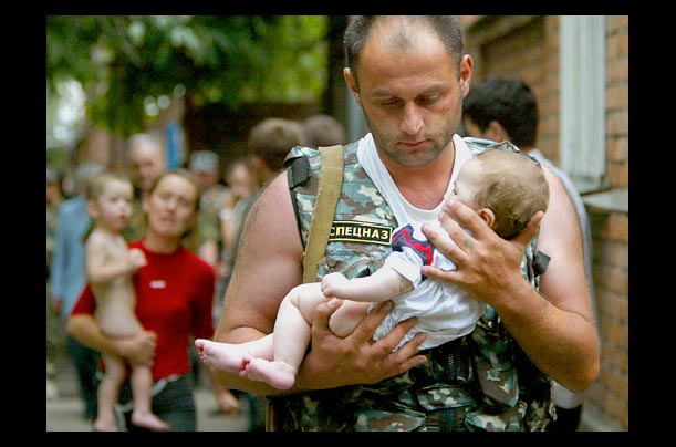russian police carry a baby held hostage by chechen terrorists in beslan, near chechnya