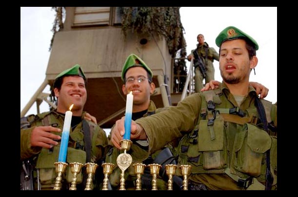 Israeli soldiers from the Nahal Brigade light candles on a Menorah at the beginning of Hanukkah, the Festival of Lights