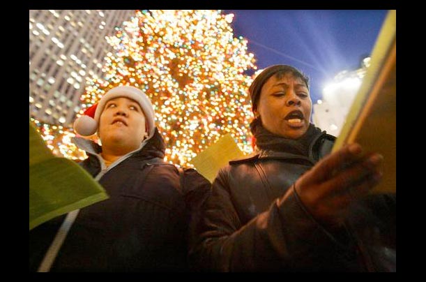 Homeless New Yorkers sing Christmas carols beneath the Rockefeller Center Christmas tree in New York City