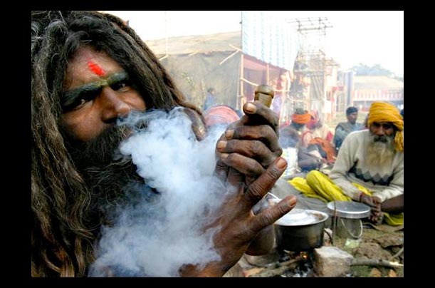 A Sandhu smokes at a gathering for the holy Gangasagar bath in the Ganges River in Calcutta, India