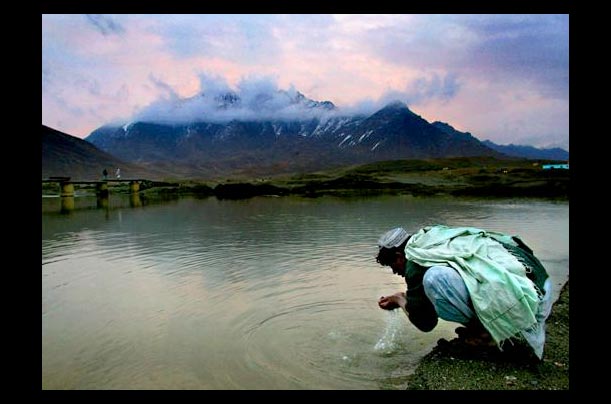 An Afghani man washes his face in a river on the eastern edge of Kabul