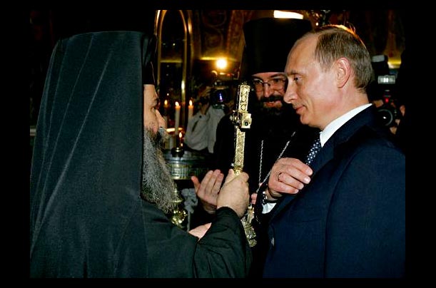 An Orthodox priest speaks with Russian President Vladimir Putin during his visit to the Church of the Holy Sepulcher, believed to the site of Jesus' final resting place