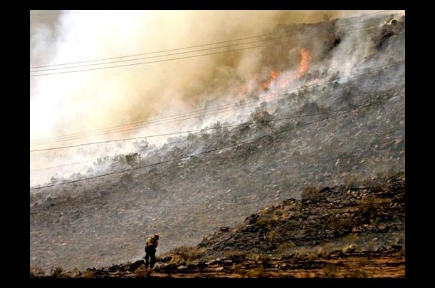 A firefighter stands near a burning near St. George, Utah