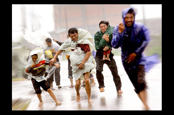 Villagers run for shelter from the rain in eastern China's Zhejian province during Typhoon Haitang