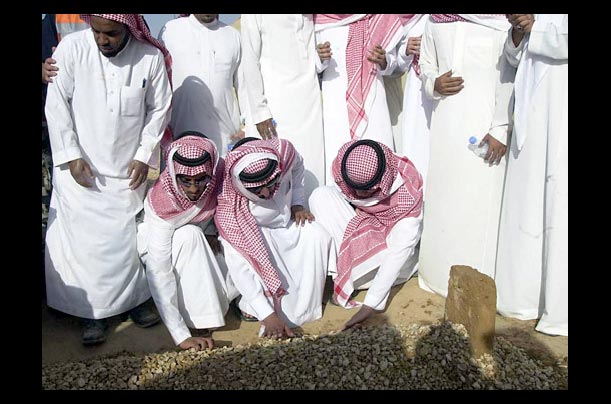 Saudi men pray over the grave of King Fahd of Saudi Arabia in Riyadh
