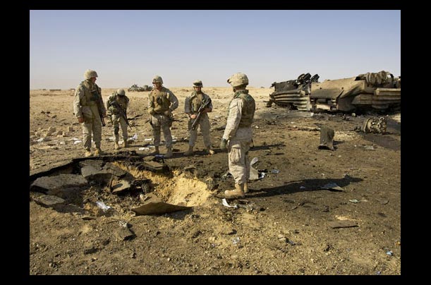 U.S. Marines inspect the site of a roadside bomb blast, which killed 14 Marines and a civilian interpreter in Barwana, near Haditha, Iraq, making it the deadliest roadside bombing in the Iraq war