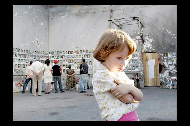 a little girl stands in the destroyed sports hall of a school in beslan, russia a year after its hostage crisis