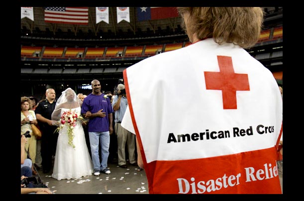 A Hurricane Katrina evacuee is escorted by boxer Evander Holyfield during her wedding at the Astrodome in Houston, Texas