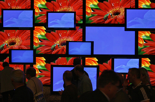 Attendees at a consumer electronics show in Berlin walk past a display of Panasonic televisions.