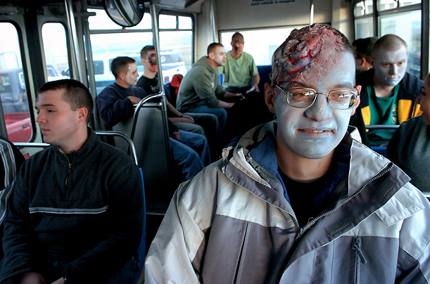 Mock disaster volunteer Matthew Ward sits in a bus with other volunteers before the start of a training exercise at the Great Falls International Airport in Montana.