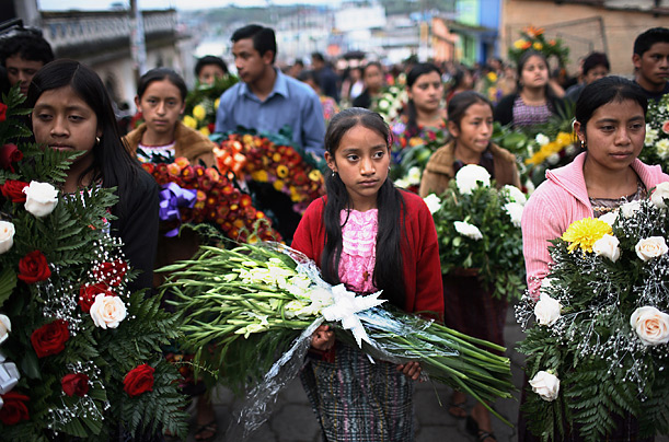 A girl carries flowers to the burial of Aura Salazar, a member of the Guatemala's Patriotic party, in Guatemala City. 


