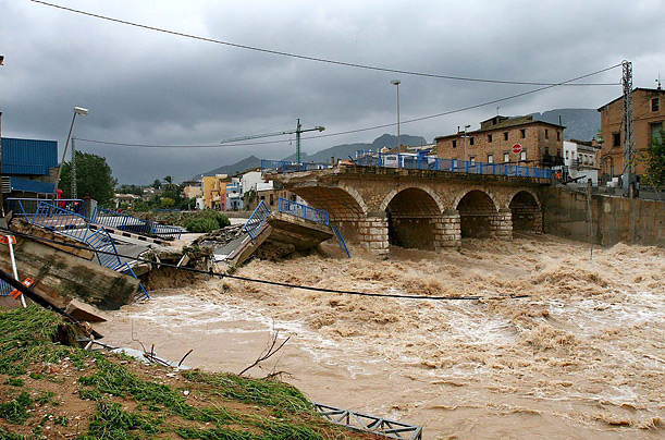 bridge washes away during flooding in Beniarbeig, Spain.