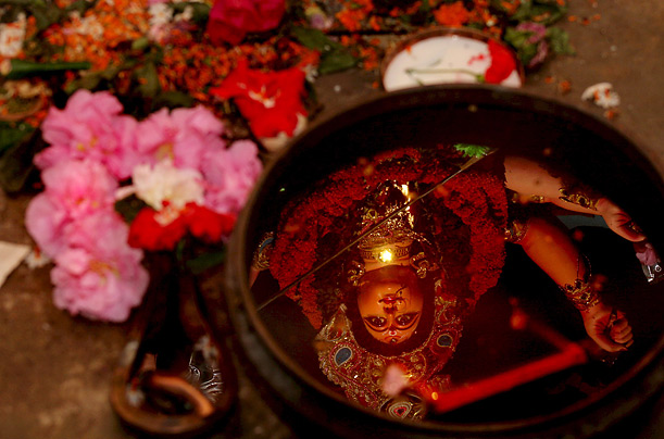 The face of Goddess Durga is reflected in holy water during the Durga festival in Calcutta. Bengalis all over the world celebrate the festival as a representation of good over evil, and female power.