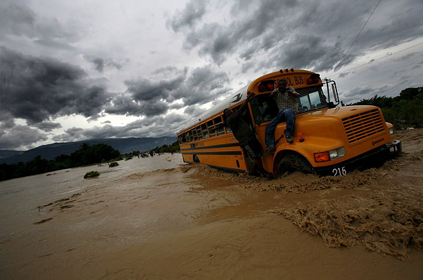 Haitians climb on a bus during a flood on the outskirts of Port-au-Prince after  tropical storm Noel hit the impoverished Caribbean nation.