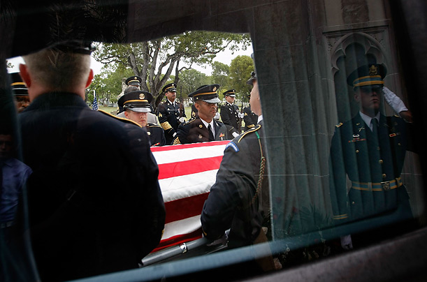 An Army Honor Guard carries the flag-draped casket of Army Pfc. Marius L. Ferrero, 23, during his funeral in Miami, Florida. He was killed by a roadside bomb while serving in Iraq.