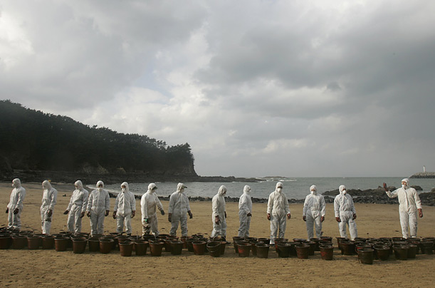 
Soldiers prepare to carry buckets containing crude oil spilled from the tanker Hebei, in Taean, South Korea.