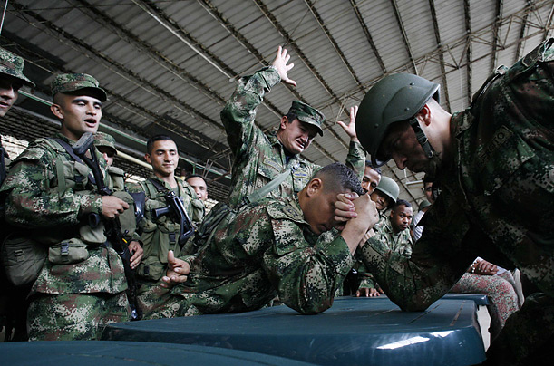 Two soldiers arm wrestle before receiving Christmas gifts in Carmen de Bolivar, Colombia.