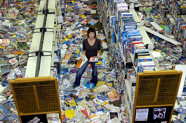 Penny Walsh poses among books thrown from their shelves during an earthquake in Gisborne, New Zealand. 
