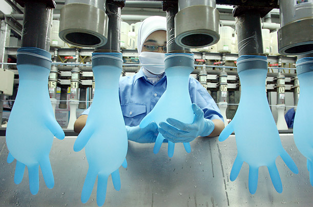 A worker inspects the quality of gloves at the Top Glove Corporation in Meru, Klang, Malaysia.