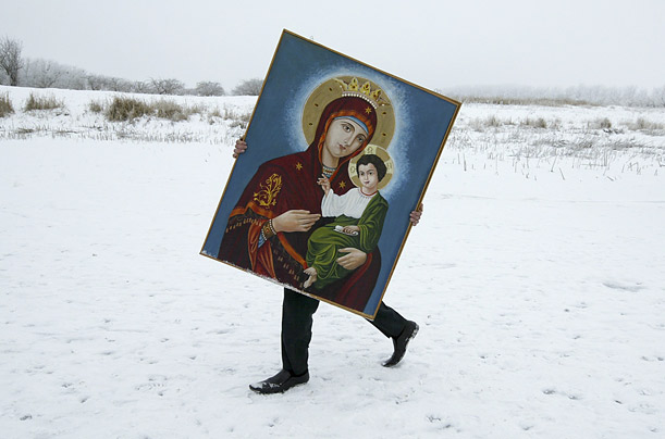 A man carries a painting during Orthodox Epiphany celebrations in the Russian village of Temnolesskaya.