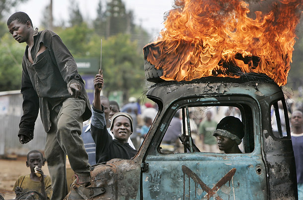 A Kenyan man sits in the cab of a burning truck used as a makeshift roadblock. The town of Kisumu is now almost completely ethnically cleansed of Kikuyus,