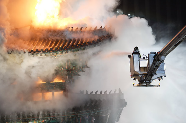 Firemen try to extinguish the fire on the Sungnyemun Gate in Seoul, South Korea, The Gate, which has a 610-year history, collapsed after the damage. 
