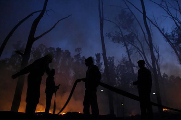 Firefighters try to douse a fire that gutted hundreds of huts in the slums of New Delhi, India.