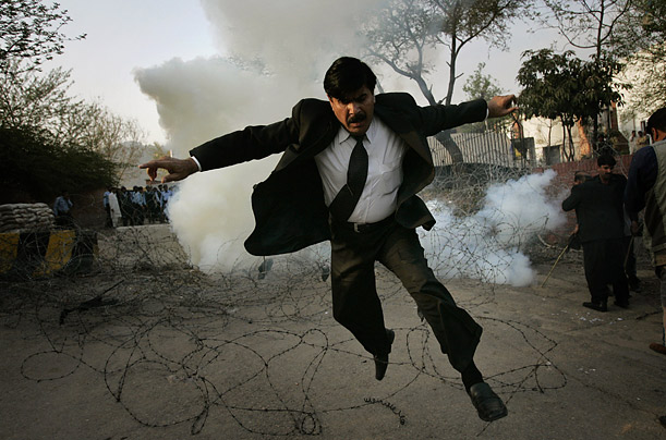 A Pakistani lawyer runs away from tear gas fired by police officers outside the residence of the country's deposed chief justice, Iftikhar Mahmoud Chaudhry,  during a protest in Islamabad, Pakistan.