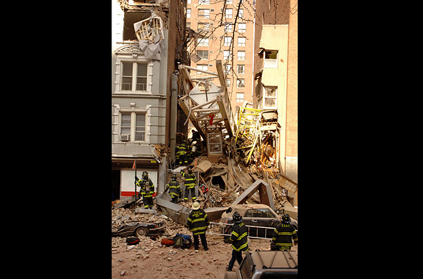 A 19-story construction crane lies amidst the ruins of a townhouse on the Upper East Side of New York, after falling across two blocks. Seven people were killed in the accident.