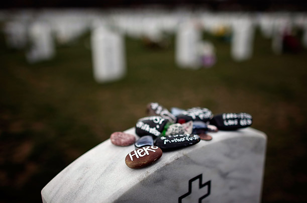 Friends and family leave stones painted with terms of endearment on top of a headstone as a tribute in Arlington National Cemetery. More than 4,000 U.S. troops have been killed in the war in Iraq.
