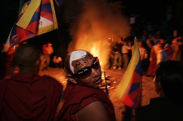 Tibetan exiles set fire to an assortment of Chinese goods collected from the residents of Dharmsala, in Dharmsala, India. The slogan on the forehead of the man in center reads 