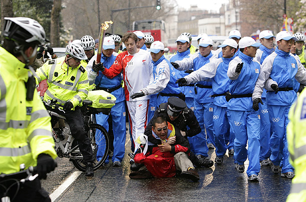 Police pull down a demonstrator along the route of the Olympic torch in London. Protesters advocating Tibet's independence disrupted the torch's path in London, Paris and San Francisco.