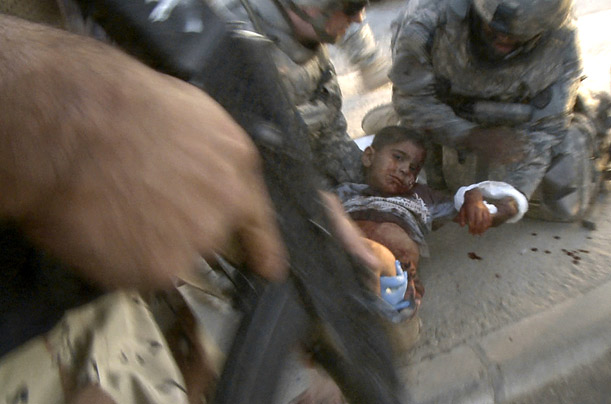 U.S. military personnel provide medical aid to a child wounded in a bombing in Mosul, Iraq.