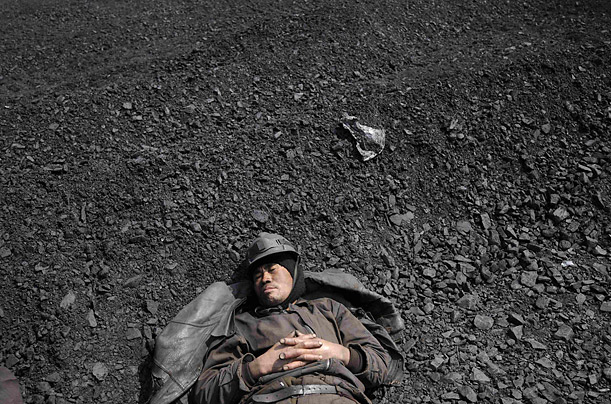 A worker rests after searching for usable coal at a cinder dump site in Changzhi, Shanxi province.
