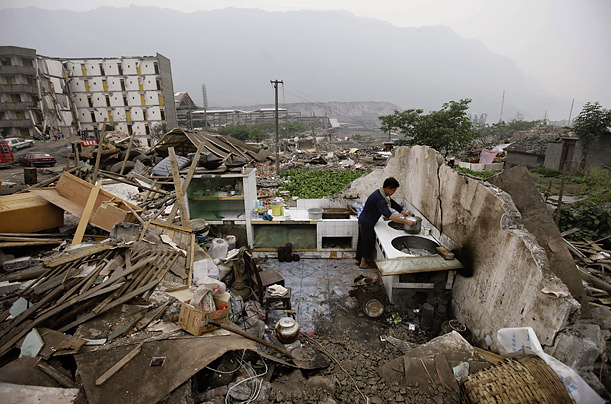 A quake survivor tries to make the most of what is left of his home in Yinghua, China.