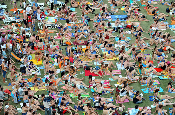 1,800 people gather on an artificial grass spread on the tarmac of the city skating rink, as part of an attempt to set a new Guinness world record for the number of people sun-bathing in a city in Budapest, Hungary.  
