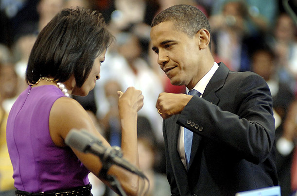 Michelle Obama, left, gives her husband, the newly anointed Democratic nominee for President, a knuckle-bump as a sign of support before he speaks to supporters at the Xcel Energy Center in St . Paul, Minnesota.