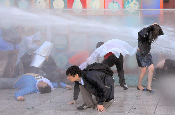 Riot policemen blast water at demonstrators protesting the government's decision to resume U.S. beef imports in Seoul, Korea.