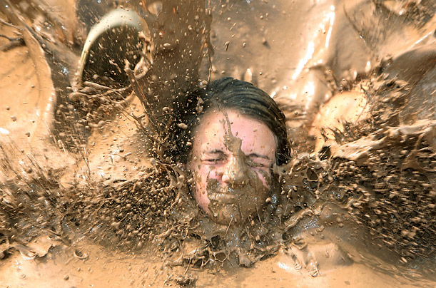 Lauren McGraw, 16, of Chandler, Ariz., sinks into a mud pit as she runs the obstacle course at Mighty Mud Mania, an annual event held at Chaparral Park in Scottsdale.


