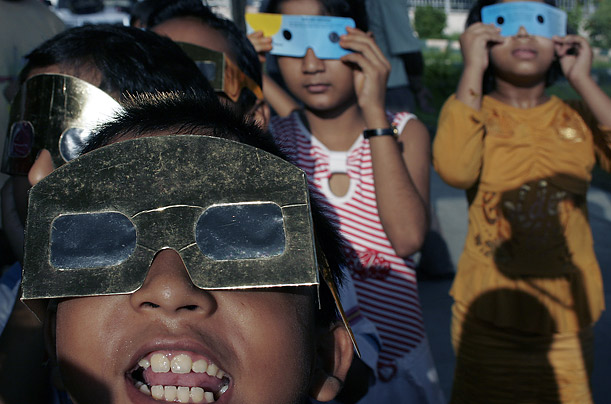 Children in Gauhati, India view the eclipse through special solar glasses at a planetarium