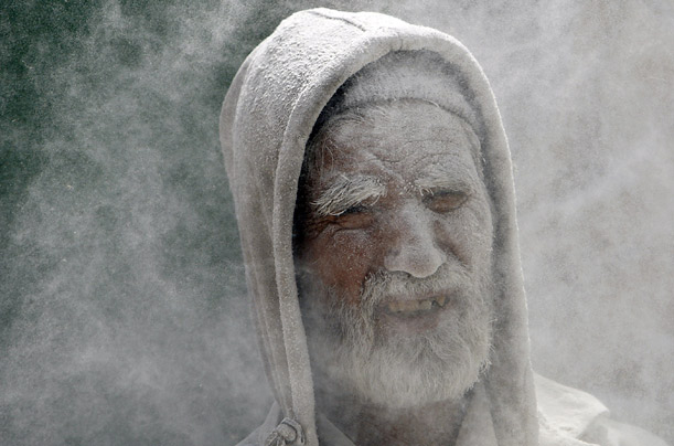 Flour covers the face of a worker at a flour market in Kabul, Afghanistan.