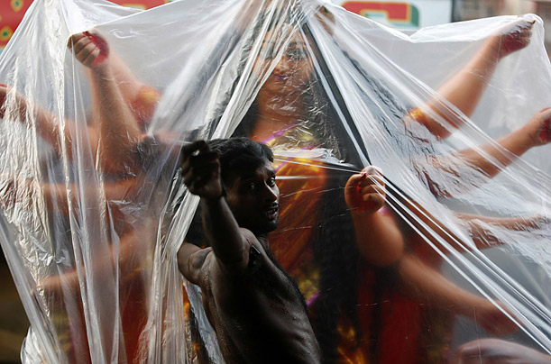 An idol of the Hindu Goddess Durga is protected with plastic while being stored in preparation of the Durga Puja festival.