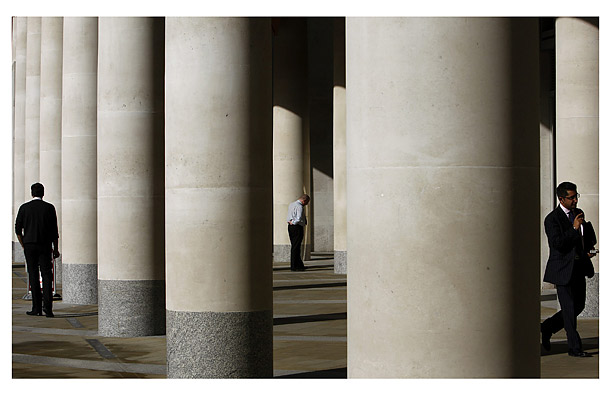 City workers circulate among the columns outside the London Stock Exchange.


