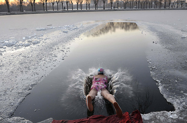 A swimmer dives into an icy lake at a park in Shenyang, China.

