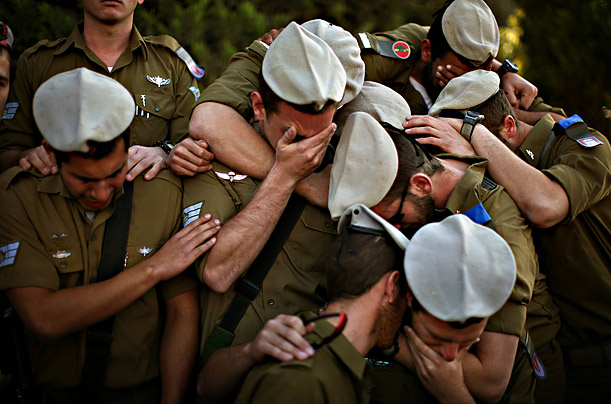 Colleagues of Israeli army Staff Sgt. Alex Mashavisky, killed during combat in Gaza, mourn over his grave during his funeral in Beer Sheva, Israel.